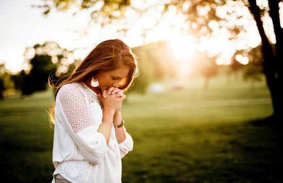 Woman in prayer in open sunlight area