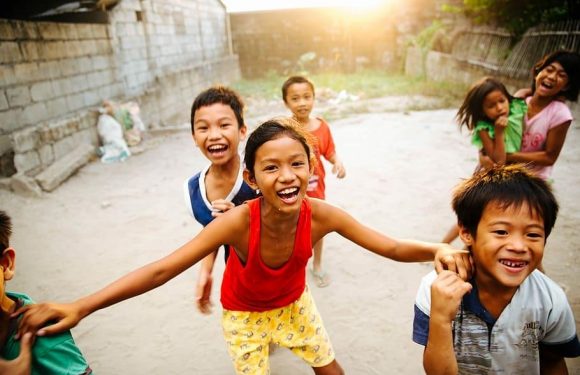 Kids smiling, playing, laughing, possibly in a 3rd world country