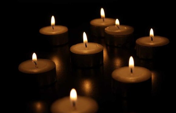 Individual candles lit in a dark room
