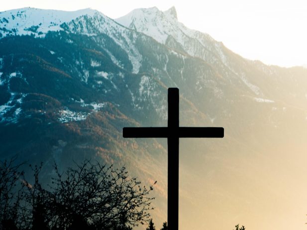 Silhouette of a Cross in front of Mountians