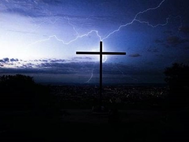 Thunderstorm landscape with cross in foreground