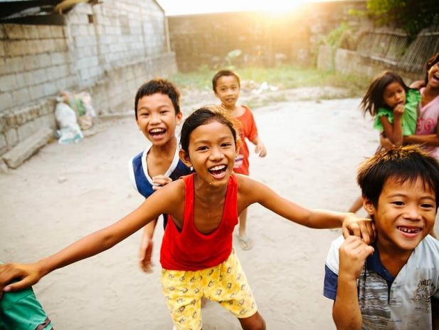 Kids smiling, playing, laughing, possibly in a 3rd world country