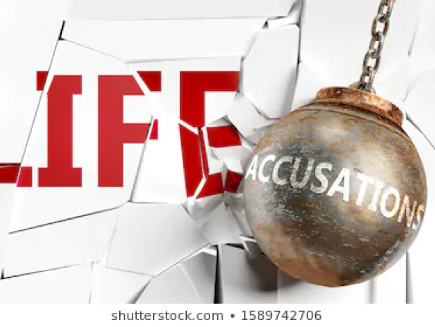 Wrecking ball with accusations written on it smashing mirror that says life