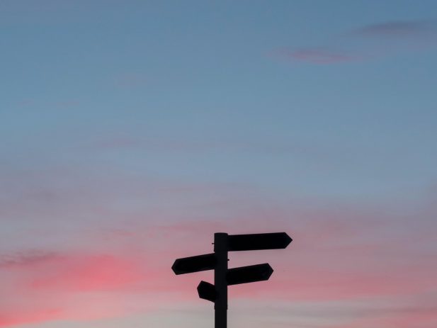 Sunset with a crossroads sign silhouette