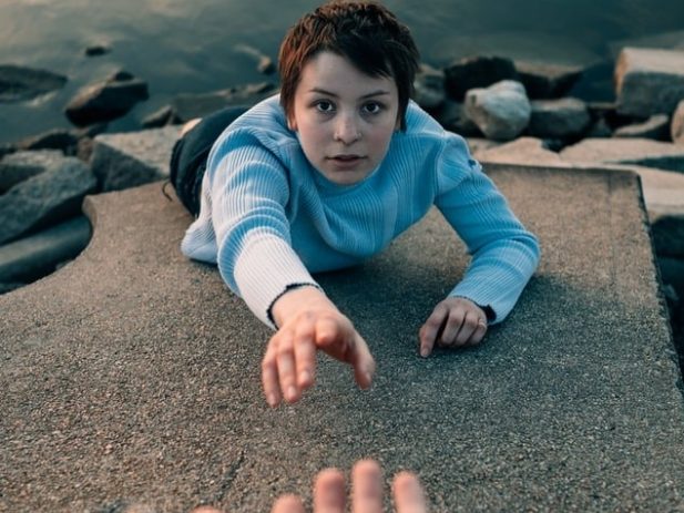 Hand reaching out to someone slipping into the water