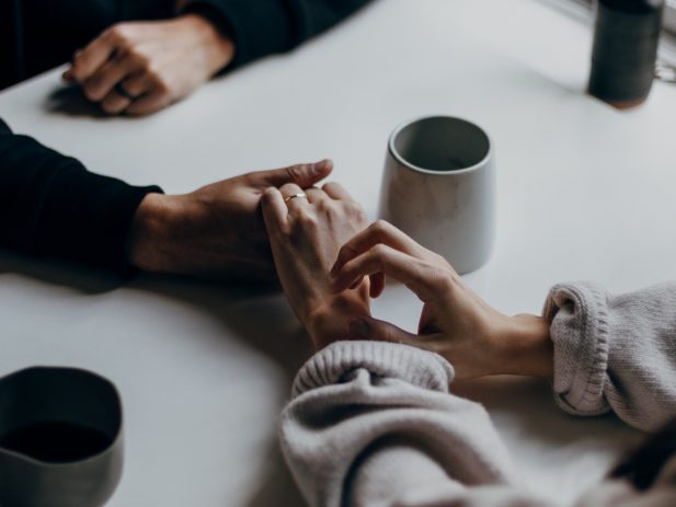 Two people holding hands during a difficult time