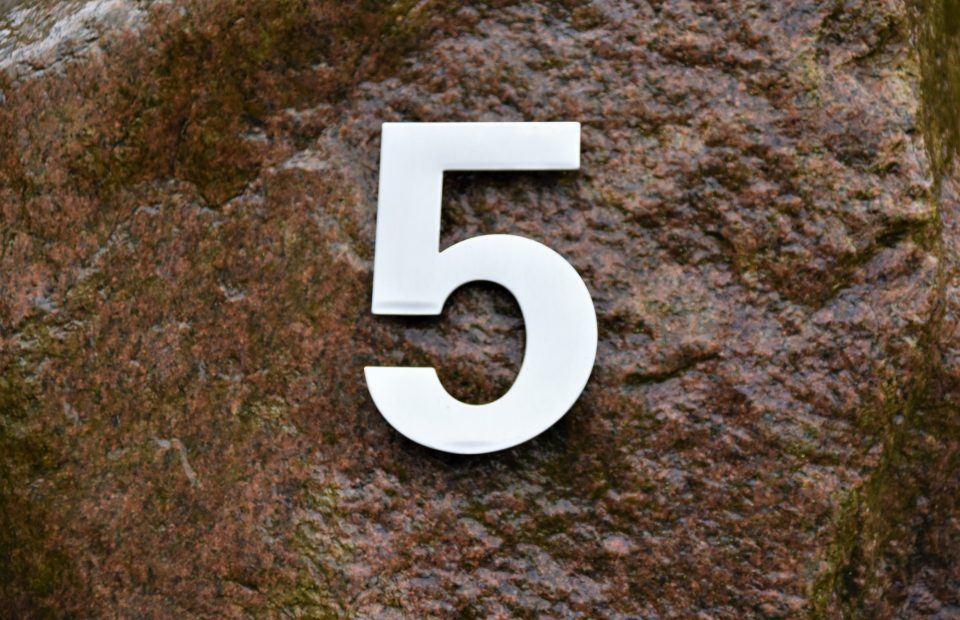 White number 5 overlaying a rock profiled background