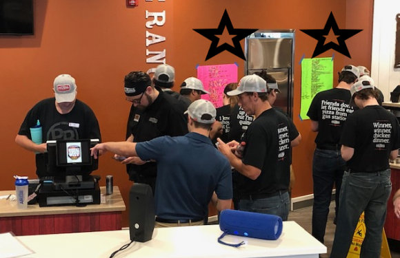 Team Members putting star stickers on poster board