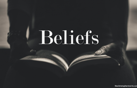 Person with open bible in lap with word beliefs in shadow