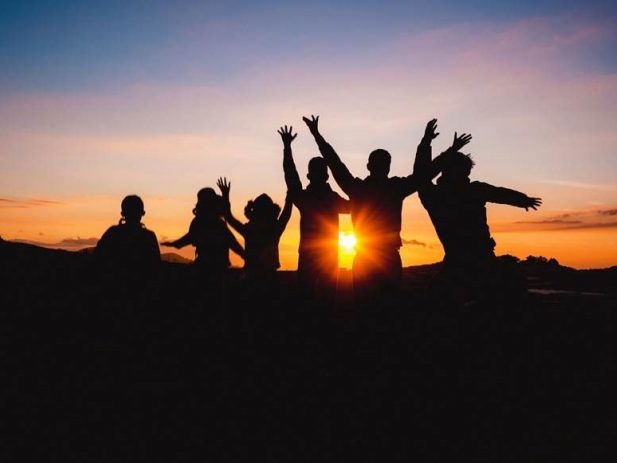 Silhouette of kids in front of a sunset